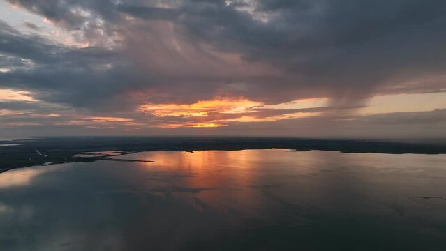 MONFALCONE, ITALY - APRIL, 2023: Sailing yacht moored off the coast Adriatic sea in Italy at sunset. Drone aerial view, cinematic frame. Romantic atmosphere. Calm and pacifying scene.