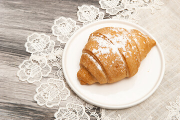 Croissants on a saucer with a napkin.