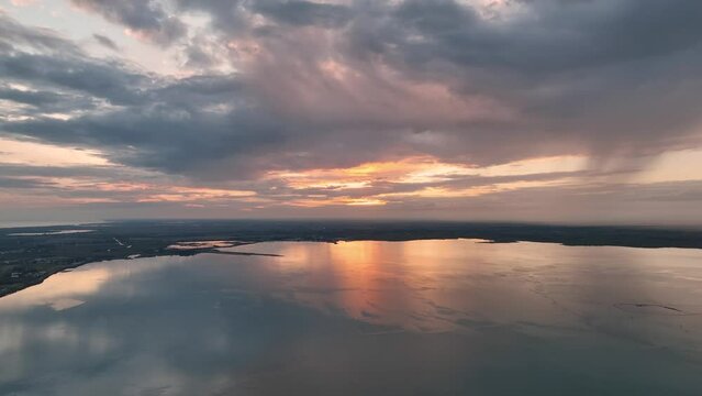 MONFALCONE, ITALY - APRIL, 2023: Sailing yacht moored off the coast Adriatic sea in Italy at sunset. Drone aerial view, cinematic frame. Romantic atmosphere. Calm and pacifying scene.