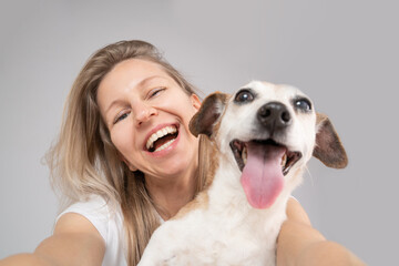 Happy friends dog and woman. Cute funny friends. focus on the face of a woman, muzzle of dog in defocus. Happy exited portrait of blonde dog owner girl and her adorable Jack Russell terrier pet 