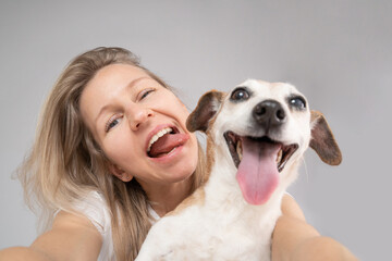 Cute funny friends. focus on the face of a woman, muzzle of dog in defocus. Happy exited portrait of blonde dog owner girl and her adorable Jack Russell terrier pet looking camera. Adventure mood