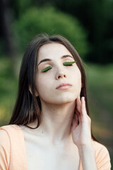 Celebrate Earth Month, Earth Day. Spend time in nature. Connect to nature is way to mitigate climate anxiety. Young woman, girl outdoors portrait on green nature background