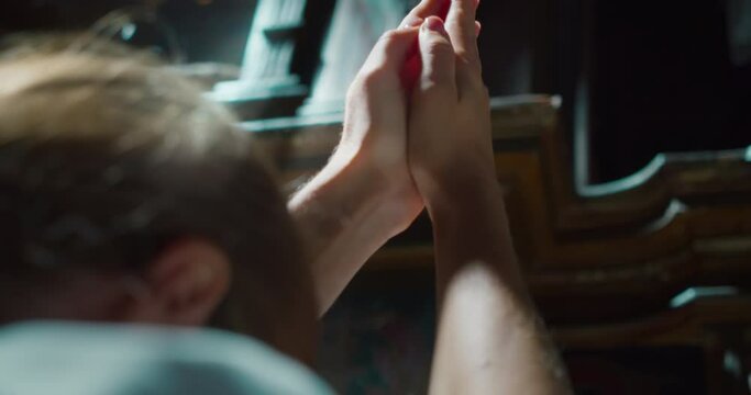 Woman raised her hands to heaven in worship to God in church. Folded hands in prayer.