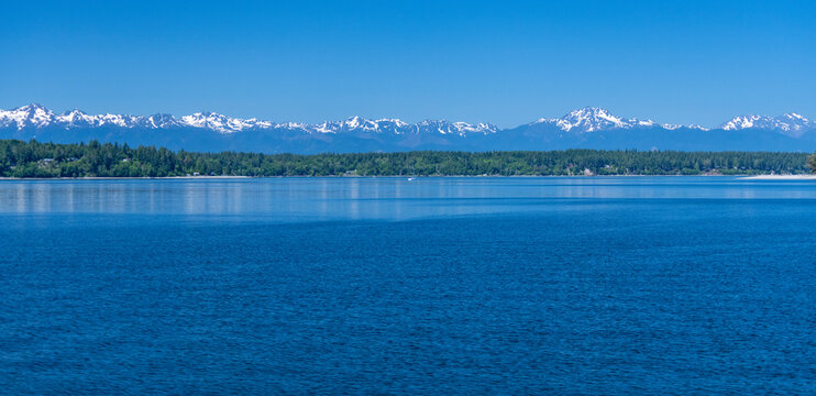 Olympic Mountains as seen on a clear Summer day about 45 miles from the middle of Budd Inlet in the Puget Sound near Olympia, Washington, USA; Washington, United States of America