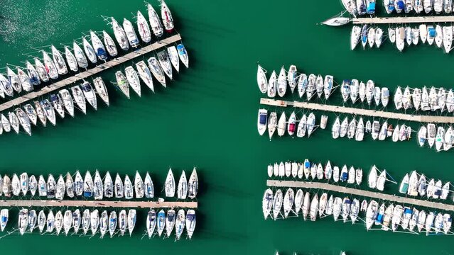 MONFALCONE, ITALY - APRIL, 2023: Sailing yacht moored off the coast Adriatic sea in Italy at sunny day. Drone aerial view, cinematic frame. Romantic atmosphere. Calm and pacifying scene.