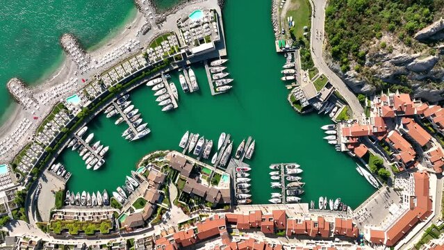 MONFALCONE, ITALY - APRIL, 2023: Sailing yacht moored off the coast Adriatic sea in Italy at sunny day. Drone aerial view, cinematic frame. Romantic atmosphere. Calm and pacifying scene.