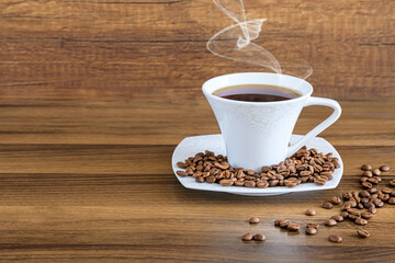 Cup of coffee with beans, coffee beans and a cup of hot drink on brown wooden background. 