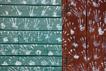 Handprints decorate the painted wood siding on the outside of a house; Jamaica, West Indies.