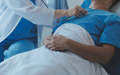 Women Asian doctors hold the patient hand and encourage and provide medical advice While checking the patient health in bed. Concept of Care and compassion, antenatal care, Threatened abortion