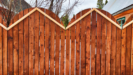 Fence made of wooden slats and snow on a winter day. Location, Background, texture, copy of space, frame as a graphic resource