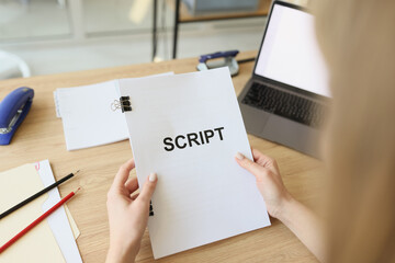 Hands of woman holding script papers for filming TV show