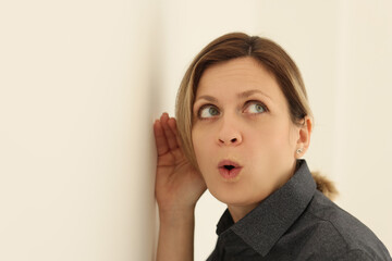 Curious woman listens to discussion of colleagues in office