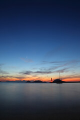 Seascape at sunshine. Lighthouse and sailings on the coast. Seaside town of Turgutreis and spectacular sunshine. Long Exposure shoot. tranquility scene. With moon and venus. 