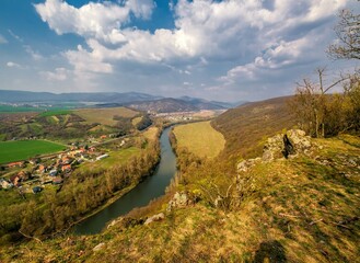 Naklejka premium winding Hron River makes its way through early spring rural farmland in the warm sunset sunlight.