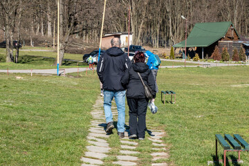 A couple of retired people are walking in the nature at a recreation center on a beautiful sunny day