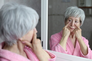 Senior woman pointing to her dark circles