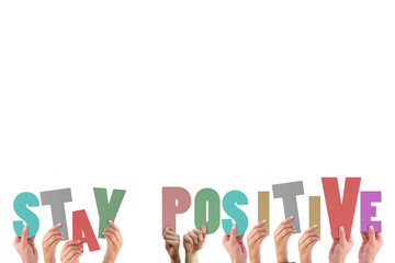 Colorful alphabet spelling stay positive held up by people 