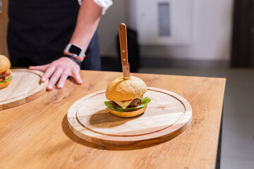 Fototapeta na wymiar Beef burgers on wooden desk. Fat unhealthy food close-up