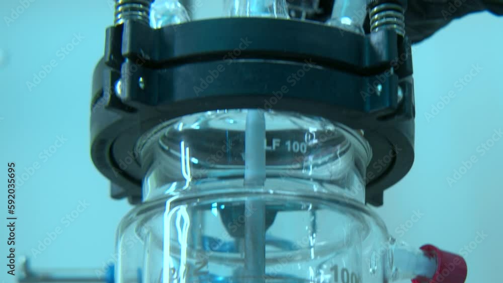 Poster chemist taking flasks with rotating equipment. stock footage. chemist in gloves takes flasks for res
