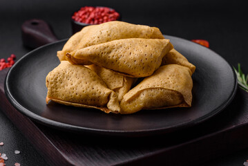 Delicious pancakes triangular shape with meat, salt and spices