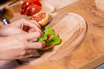 Preparing delicious burgers. Chef cooking meat burgers with beef, cheese and vegetables. Close-up