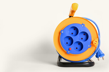 Extension electric cable reel on light background
