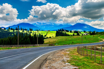 Highway in snow-capped peaks.  The highway is in the high mountains with the snow-capped peaks.  