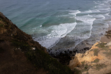 Aerial of Lagos Portugal views of Praia do Camilo and lighthouse at sunrise. Beautiful natural beaches and cliffs