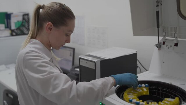 Modern medical equipment for the analysis of blood and biological fluid. Female lab technician works in a robotic modern biochemistry laboratory. Microbiology scientific hospital research samples. 