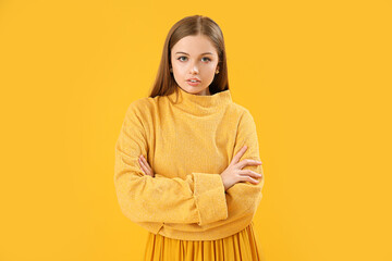 Fashionable young woman in knitted sweater on yellow background