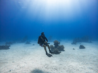 Scuba diver relaxes in the water. He is diving on a Coral Reef