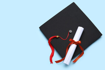 Diploma with red ribbon and graduation hat on blue background