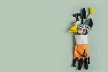 Protective glove with hand tools and flowers with copy space. Gardening, planting still life...