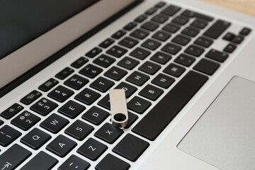 USB flash drive on modern laptop, closeup