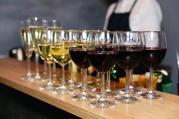 Glasses of different wines on bar counter, close-up view