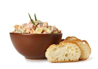 Bowl of tasty Olivier salad and bread on white background