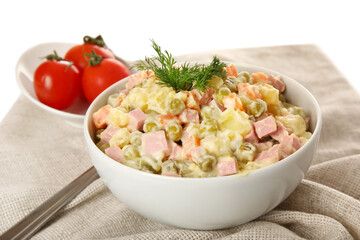 Bowl of tasty Olivier salad on white background