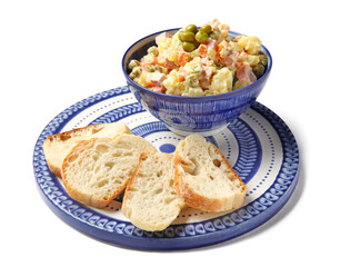 Bowl of tasty Olivier salad and bread on white background