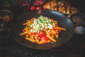 Delicious Penne Pasta with Tomato Sauce: Cherry Tomatoes, Creamy Feta Cheese, Flavorful Italian Dish, Hearty Comfort Food, Fresh Ingredients, Tasty Combination, Satisfying Meal, Appetizing Presentatio