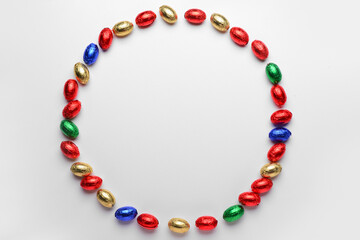 Naklejka premium Frame made of chocolate Easter eggs in foil on white background