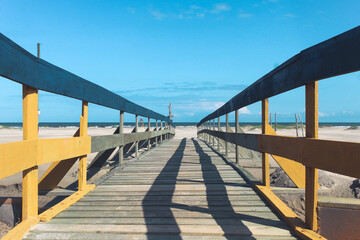 Naklejka premium wooden bridge on the beach on Ilha Comprida beach, south coast of São Paulo, Brazil.