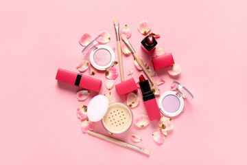 Decorative cosmetics with brushes and floral petals on pink background