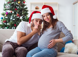 Young family expecting child baby celebrating christmas