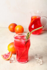 Glass of tasty blood orange lemonade on light background