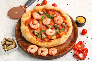 Plate with tasty seafood pizza on light background