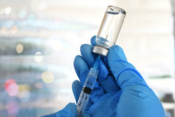 Medical personnel filling a syringe needle with generic vaccine booster from vial - obrazy, fototapety, plakaty