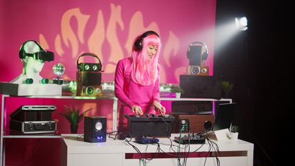 Smiling dj artist wearing headphones during performance, mixing eletronic sound with techno playing...