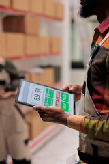 Worker holding tablet computer checking inventory report, working at customers order preparing...