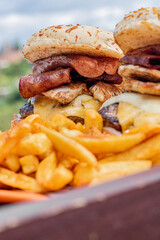 hamburguesas jugosas, queso, tocino, carne, y ricas papas freídas.