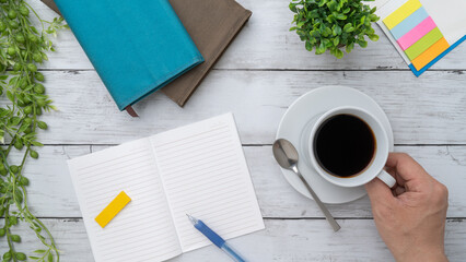 勉強イメージ｜白い木目背景と本・ノート・付箋紙・コーヒーを持つ手